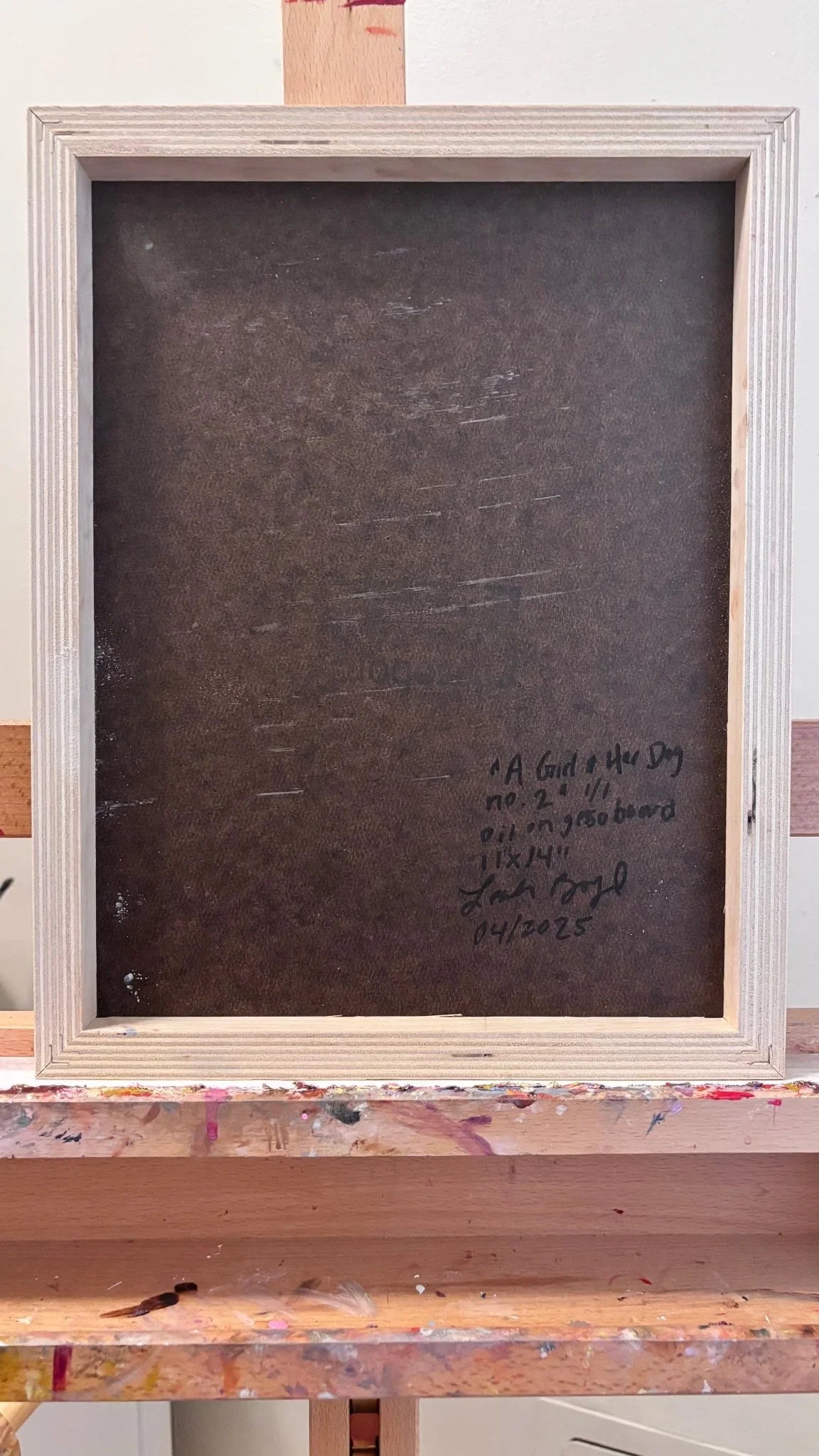 On a paint-splattered easel sits "A Girl & Her Dog no. 2," an original oil on gesso-board by Leah Boyd, with handwritten notes—title, size, medium, signature, and date "04/2025"—on the back.