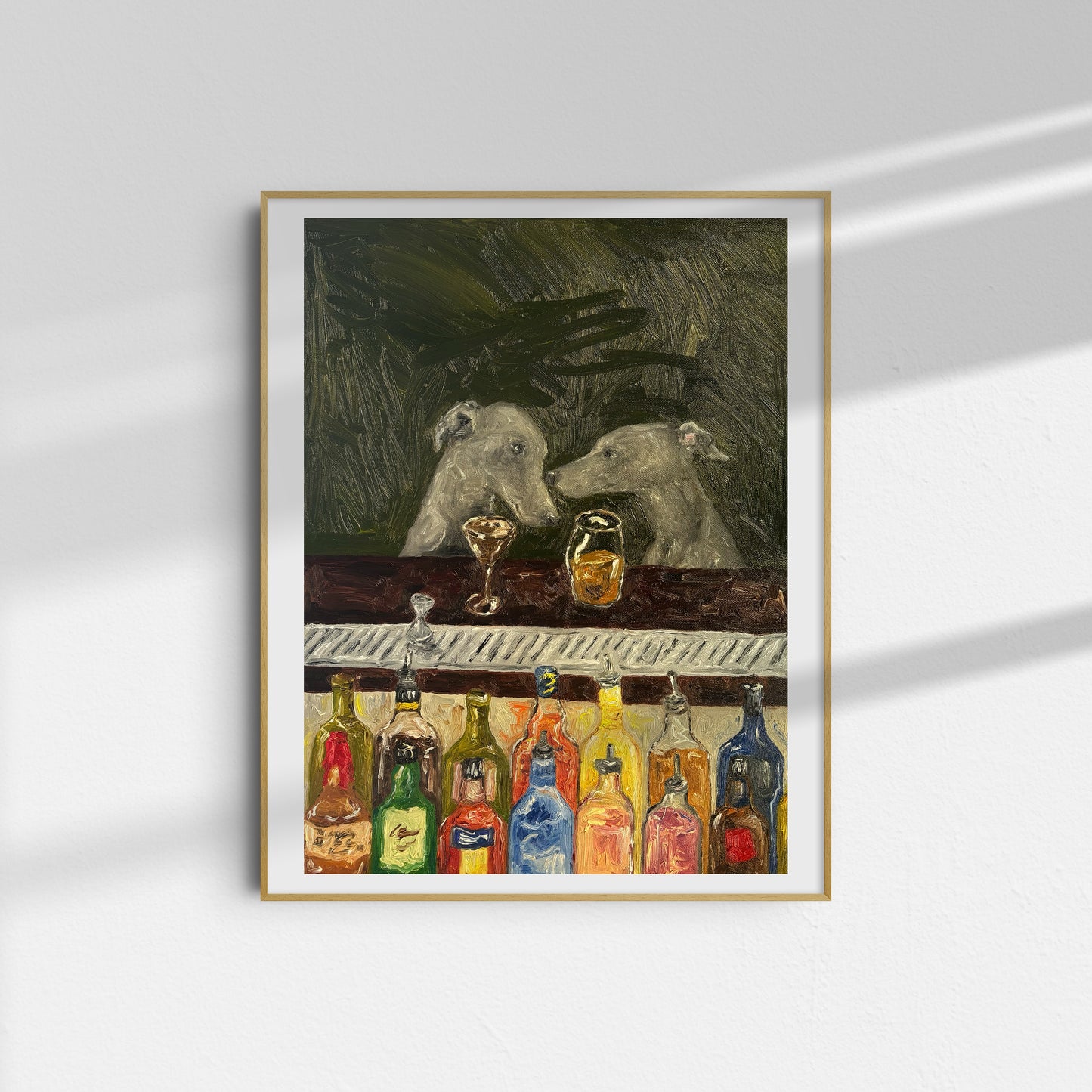 The Bar Scene [PRINT PREORDER] by Leah Boyd is a framed limited edition art print featuring two dogs at a bar with colorful bottles, set against an abstract dark background. The frame casts a shadow on the white wall.