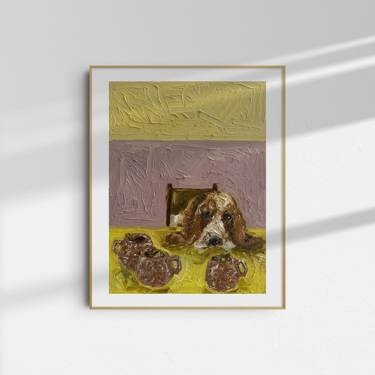 The Moscow Mule [PRINT PREORDER] by Leah Boyd is a framed limited edition Giclee print featuring a brown and white dog beside two pitchers, set against yellow and lavender hues, in a thin gold-bordered frame on a white wall.