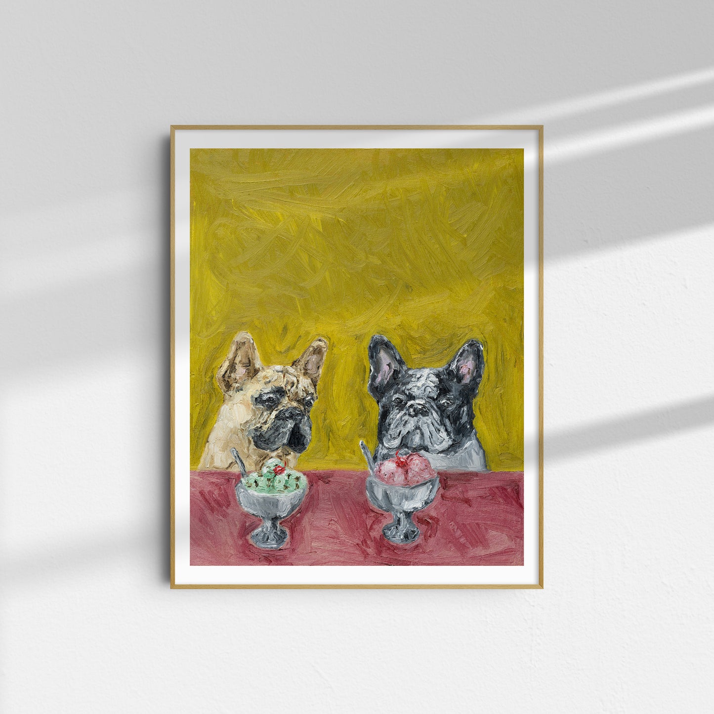 À la Mode by Leah Boyd is a framed giclee print featuring two French bulldogs seated at a table with ice cream sundaes, set against a cheerful yellow background.