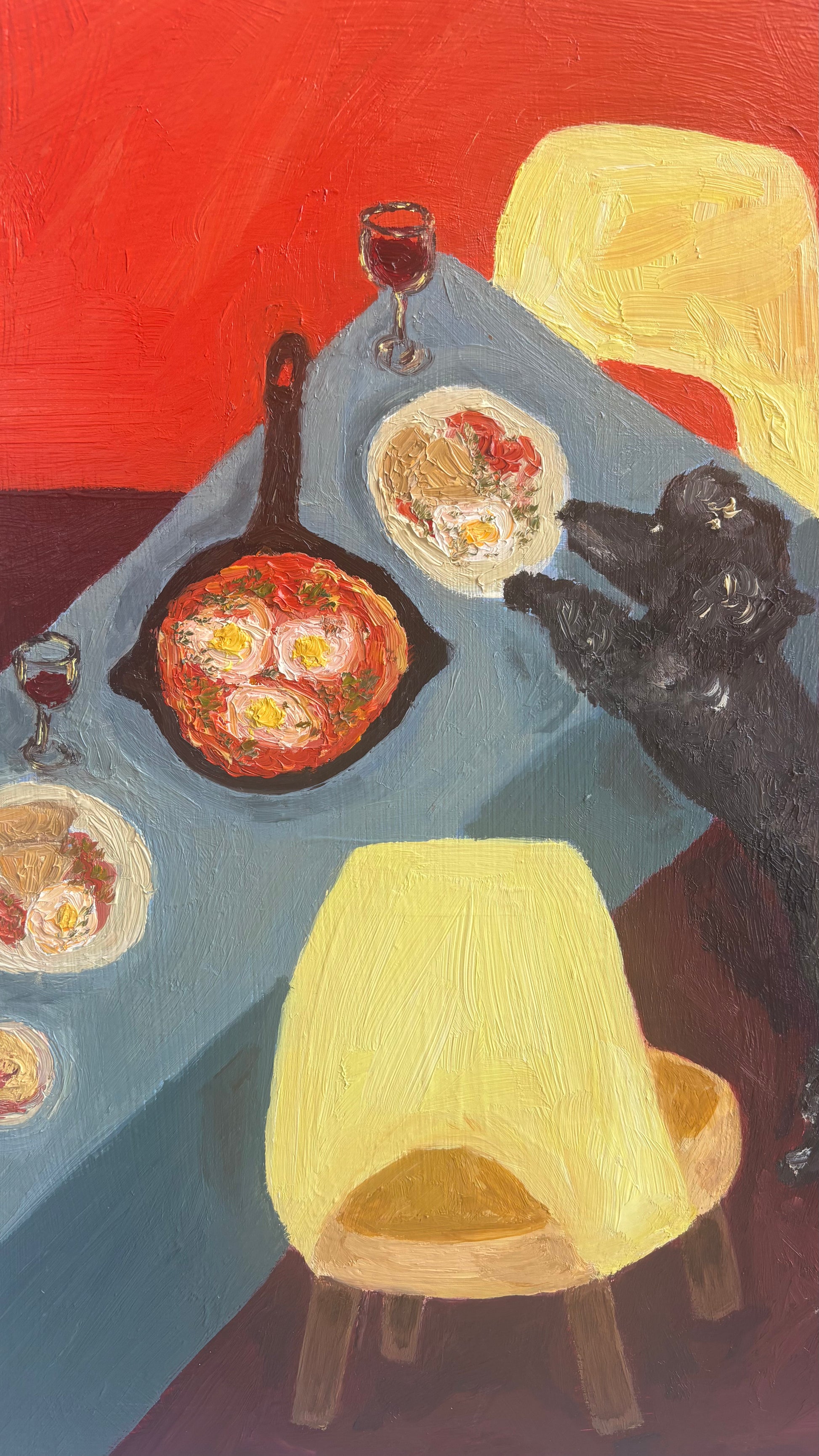 “Dinner for One no. 5: Shakshuka” by Leah Boyd is an original oil painting on cradled wood panel featuring a blue table with bowls of food, a skillet, red wine, yellow chairs, and a black dog against a vivid red backdrop.