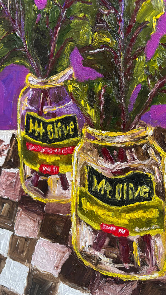 Leah Boyd’s vibrant oil painting, "Mt. Olive Pickles and Collard Greens," features two Mt. Olive jars with leafy greens on a checkered surface against a purple backdrop. Paint application is thick and textural.