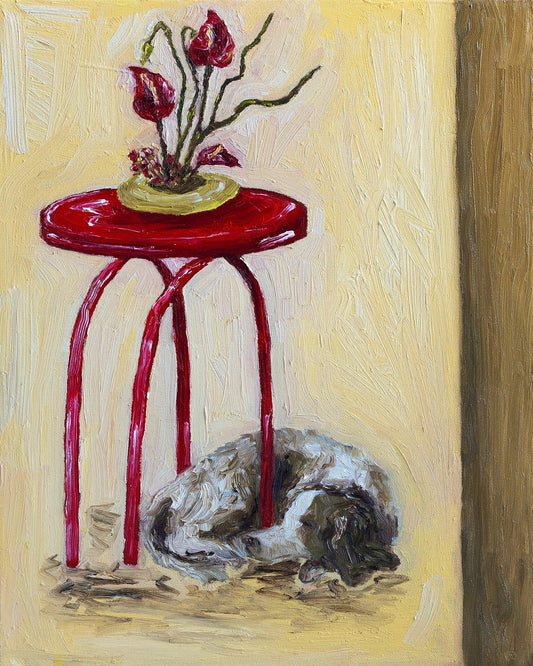 Leah Boyd’s ‘English Springer Spaniel and Ikebana’ is an original oil painting featuring a red table with a vase of red flowers, while a brown and white English Springer Spaniel sleeps below on a beige background. Paint application is thick and textural.