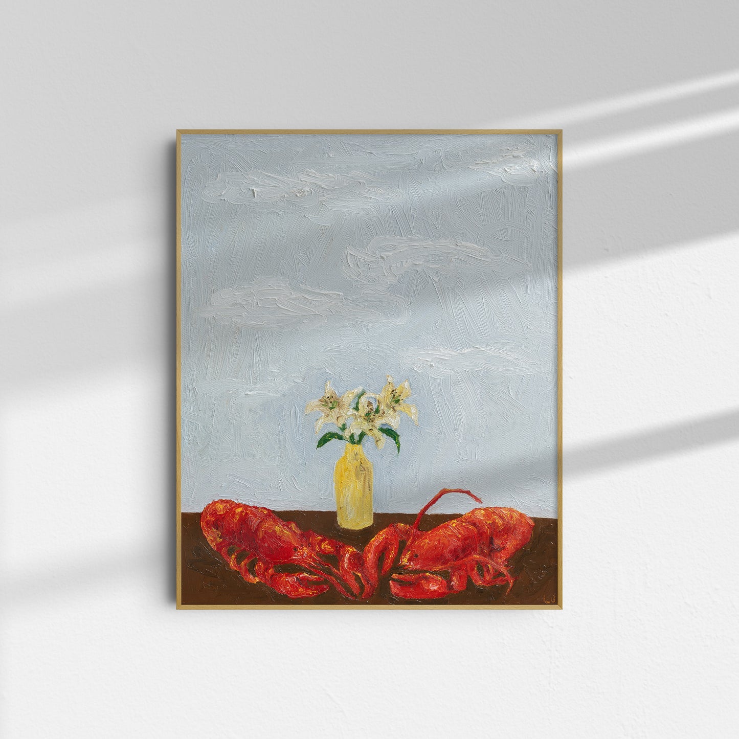 ‘Til Death Do Us Part or Consider the Lobster’ by Leah Boyd, a framed art print featuring a red lobster on a table with a yellow vase and white flowers against a cloudy blue sky, hangs on a white wall with shadows.