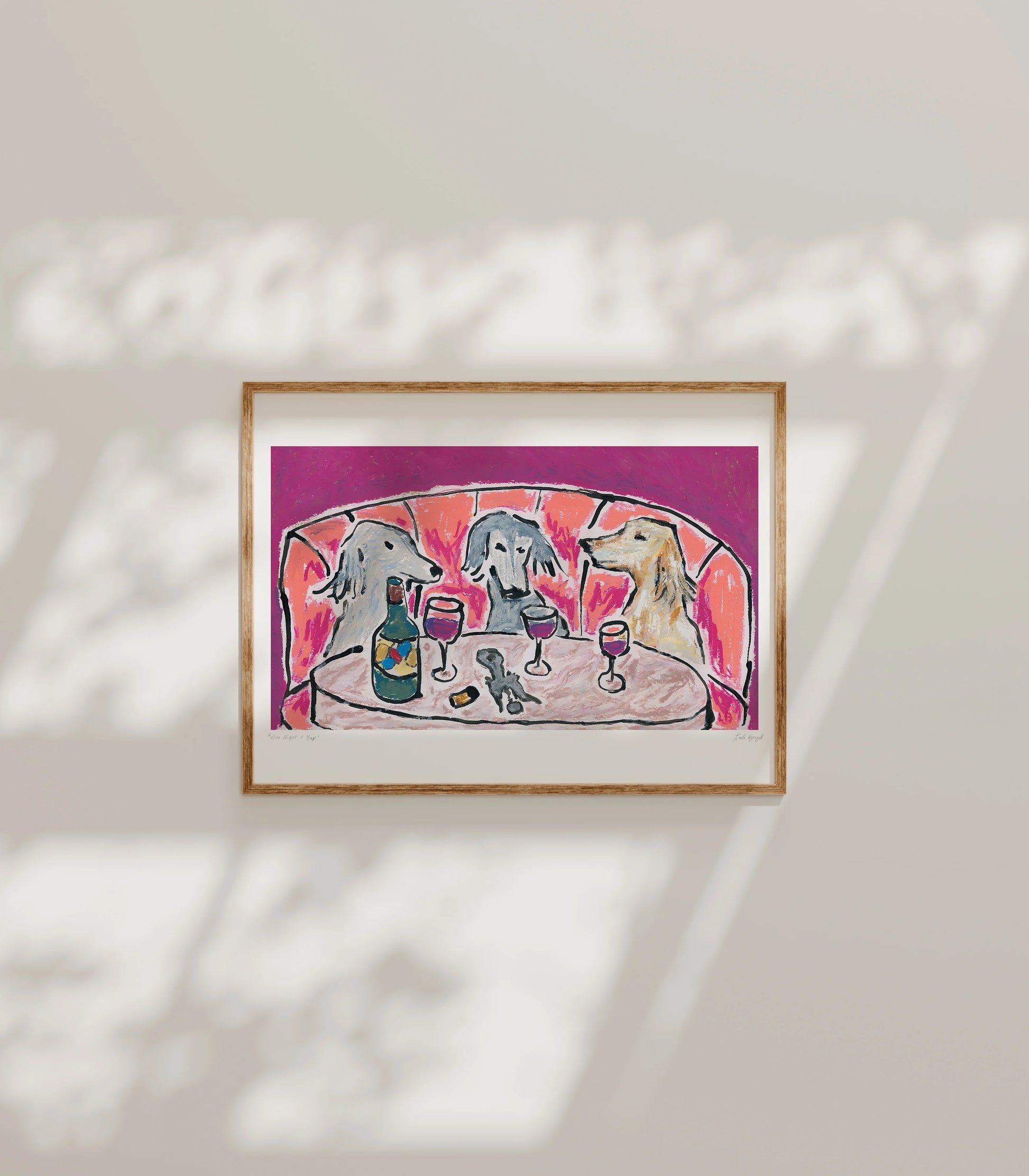 Leah Boyd's "Wine Night & Yap" is a framed giclee print on archival matte paper, showing three dogs with wine at a table against a red backdrop, sunlight casting gentle shadows in this charming open edition artwork.